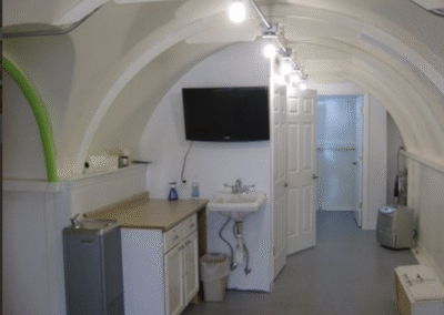 Above-ground storm shelters are anchored with steel bolts and reinforced concrete to prevent uplift during tornado winds.